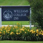Williams College placard among a plot of daisies in bloom.
