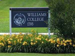 Williams College placard among a plot of daisies in bloom.